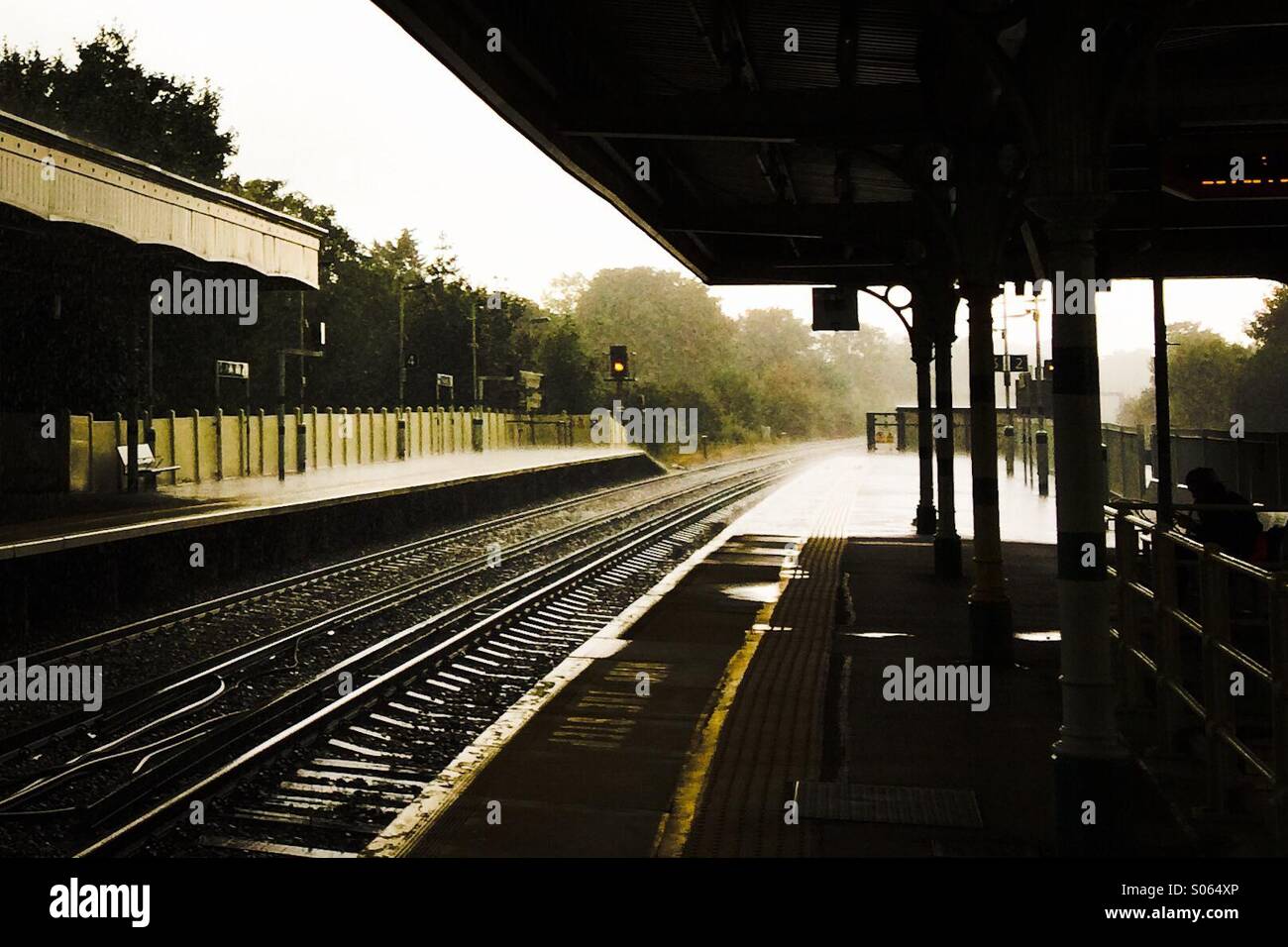 Warten auf den Zug auf einer leeren Plattform in einem Londoner Vorort Station UK Stockfoto