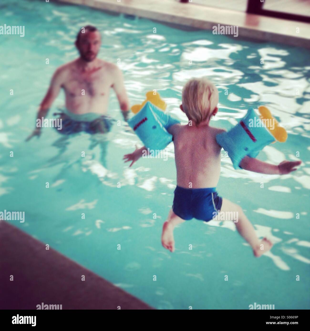 Junge springt in pool Stockfoto