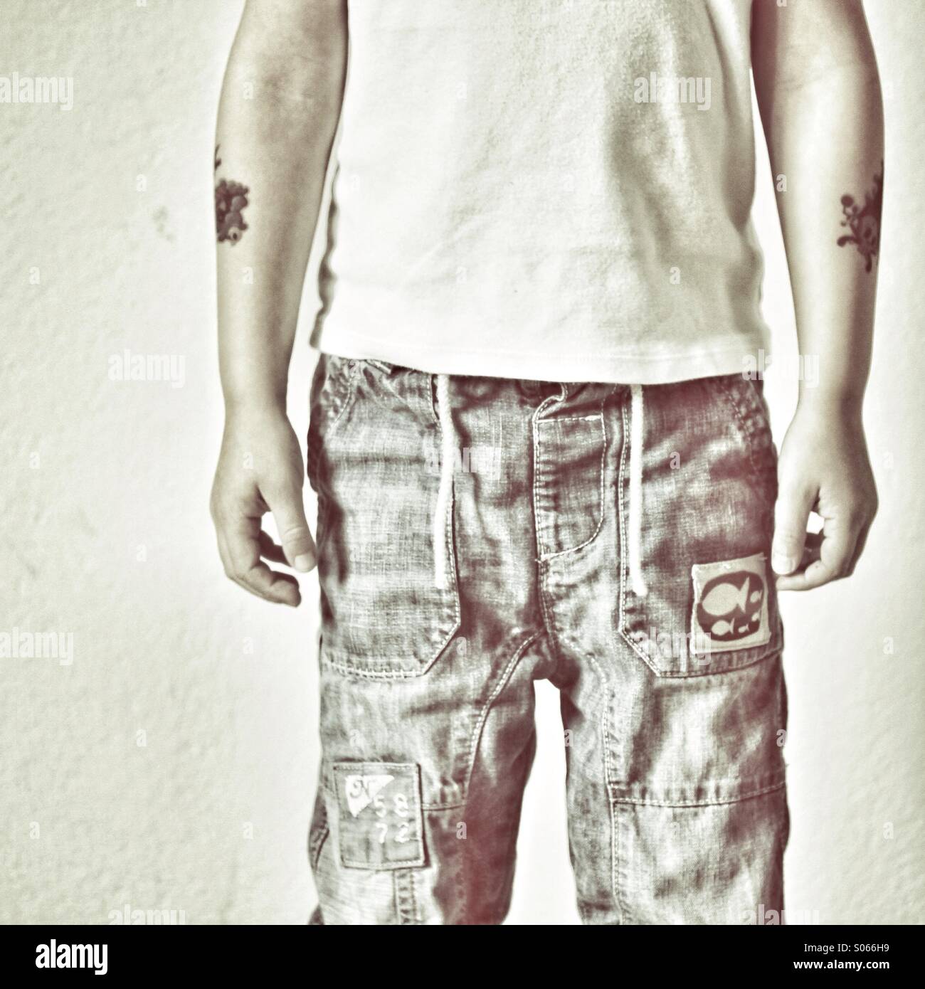 Torso des Kindes in Jeans mit tattoos Stockfoto