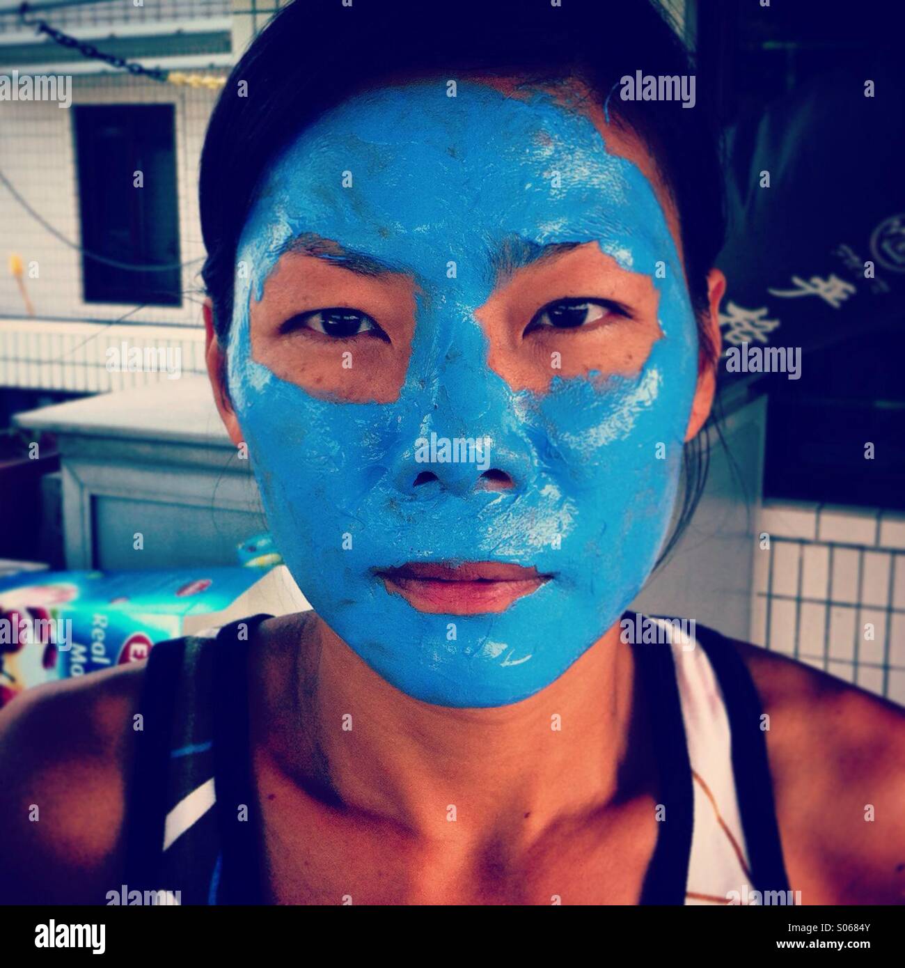 Ziemlich Asian Frau mit blauen Gesichtspflege-Behandlung - Smartphone-aufgenommenes Stockfoto