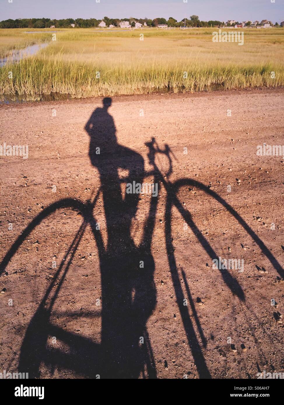 Ein Schatten von einem Mann auf einem Fahrrad auf einem Feldweg in New England, USA. Stockfoto