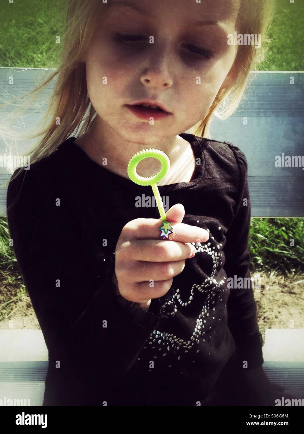 Ein Kind und ihre Blase Zauberstab machen. Stockfoto