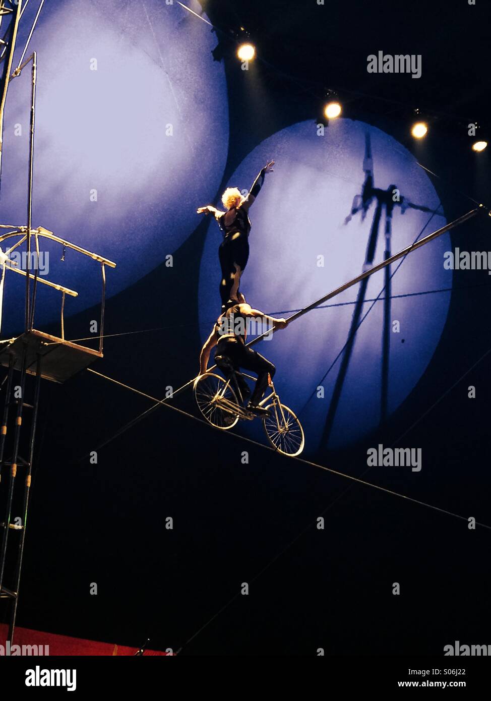 Hochseil-Künstler auf einem Drahtseil auf einem Fahrrad im Zirkus Stockfoto