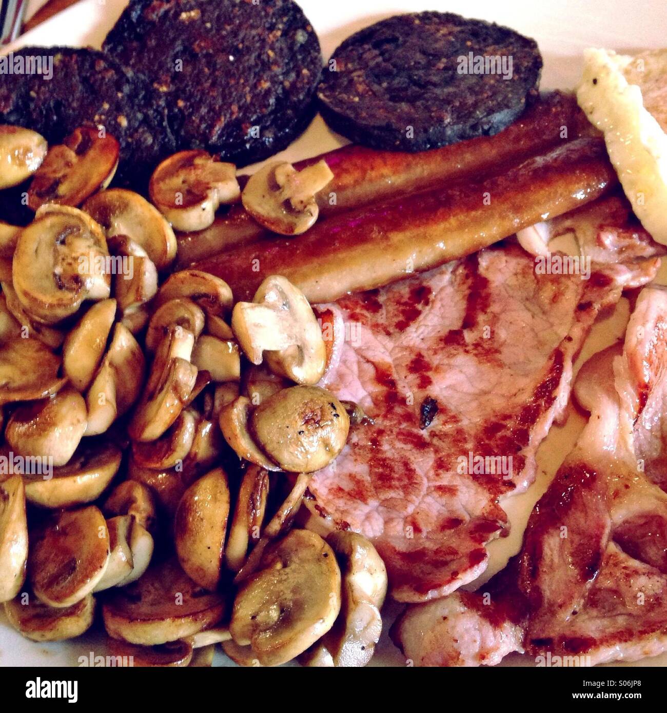 Englisch Frühstück mit Blutwurst, Pilze, Speck, Würstchen und Ei Stockfoto
