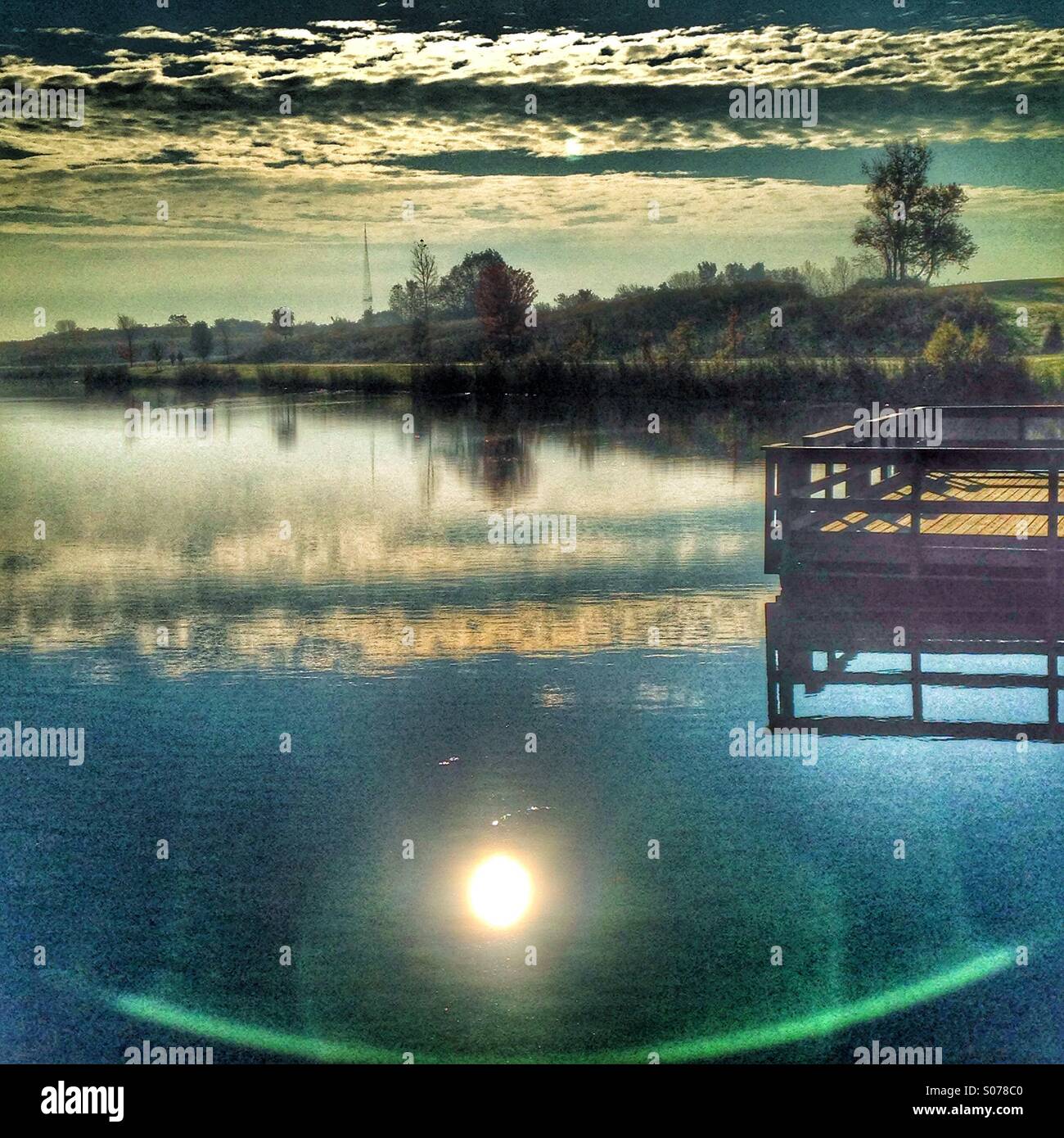Ein Deck über einen See mit Sonne Reflexion. Stockfoto
