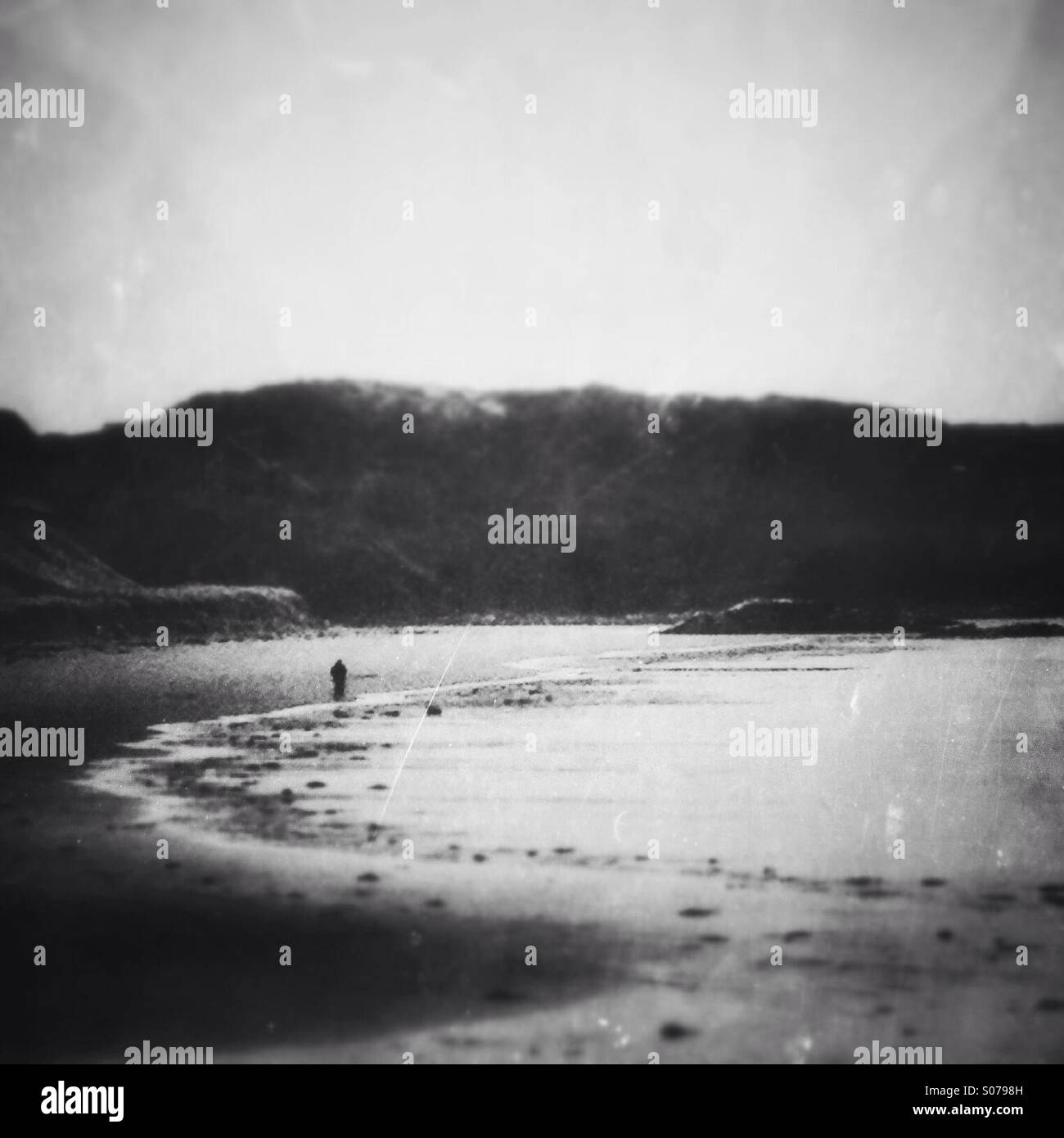 Einsame Person zu Fuß entlang der Küste. Alten Stil Effekte und Texturen hinzugefügt. Stockfoto