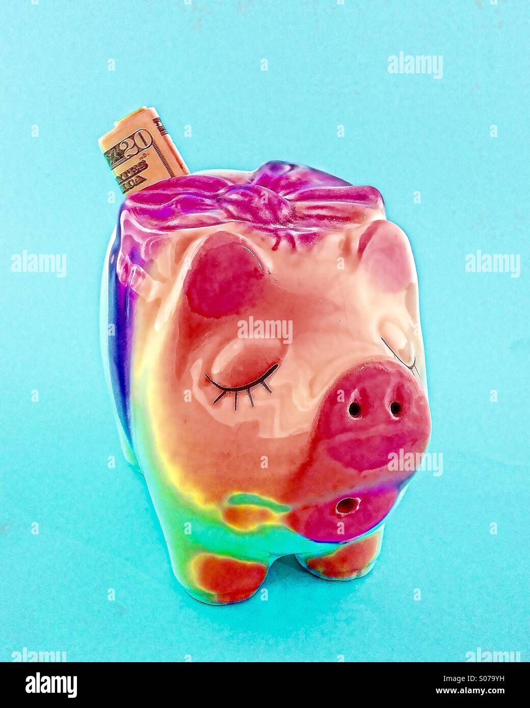 Ein Oldtimer Sparschwein mit 20 Dollarschein gefaltet in den Geld-Steckplatz. - Smartphone-aufgenommenes Stockfoto