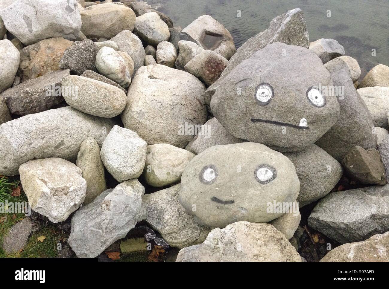 Bemalte Gesichter auf Felsbrocken Stockfoto