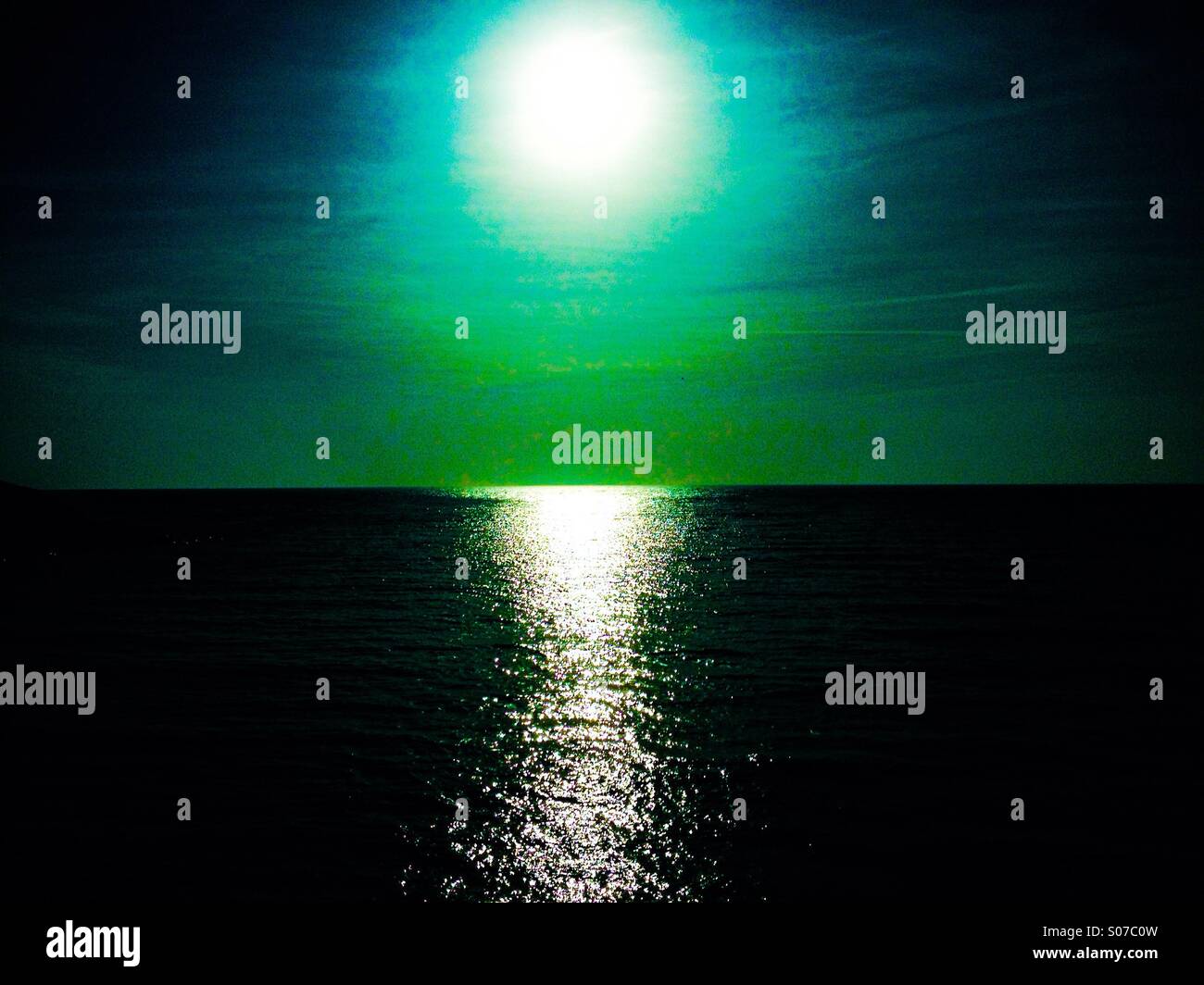Dunstige Sonne und Reflexion am Meer Stockfoto