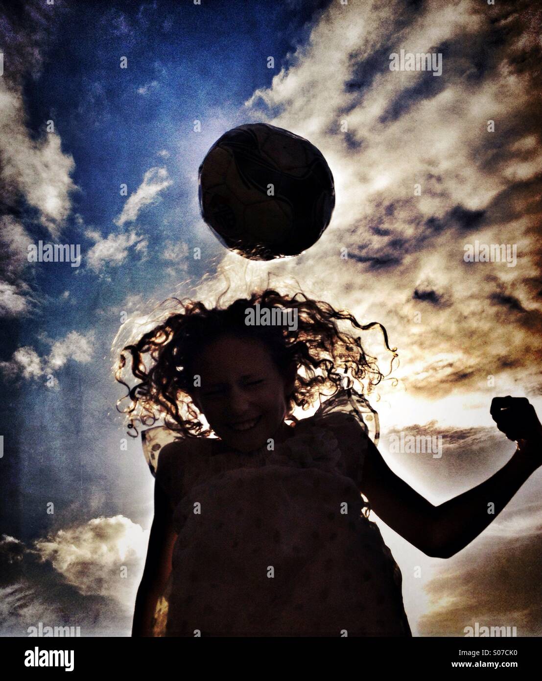 Mädchen Rubrik Fußball Silhouette gegen dramatischer Himmel Stockfoto