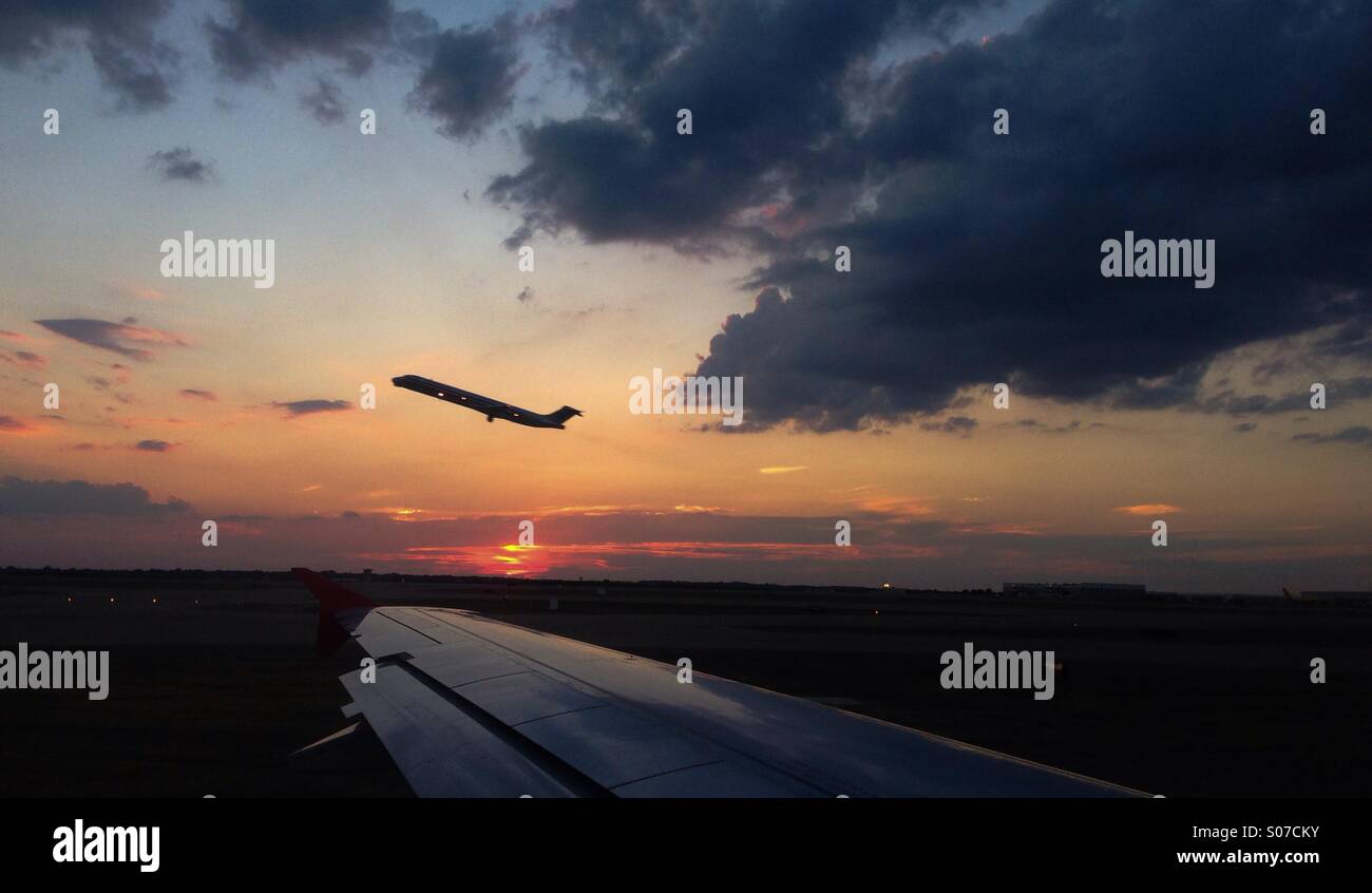 Eine Passagier Sicht als ein Düsenflugzeug zieht gegen einen wunderschönen Sonnenuntergang. Stockfoto