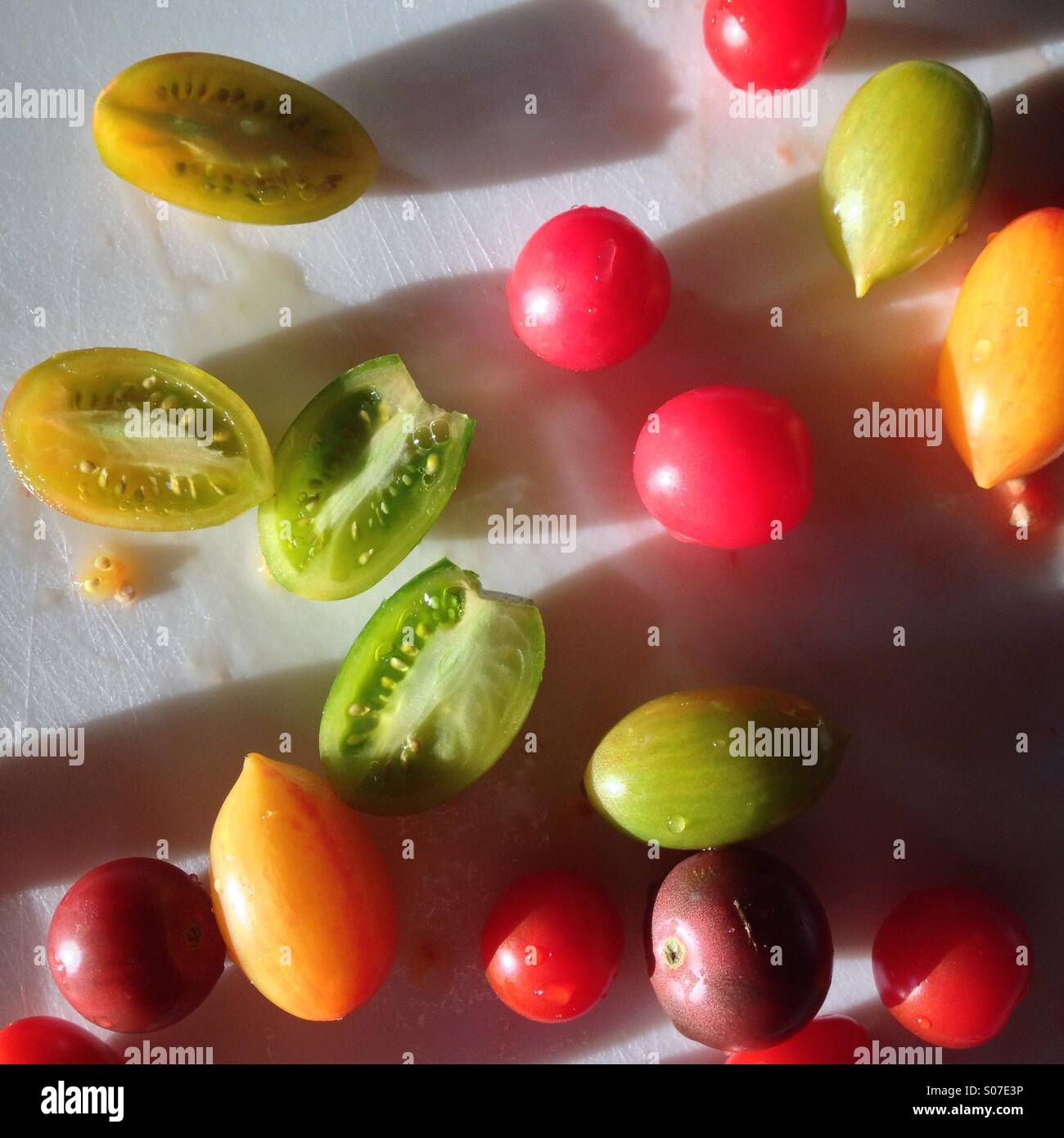 Bunte bunte Mini-Tomaten auf Schneidebrett. Stockfoto