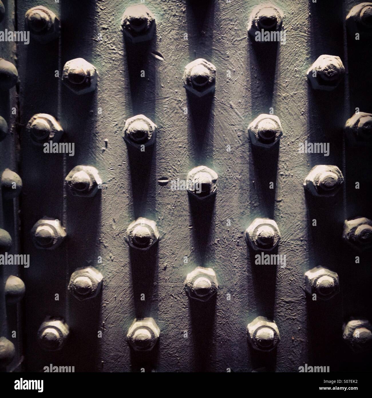 Klobige Bolzen in einer technischen Träger in einem sich wiederholenden Muster - Smartphone-aufgenommenes Stockfoto