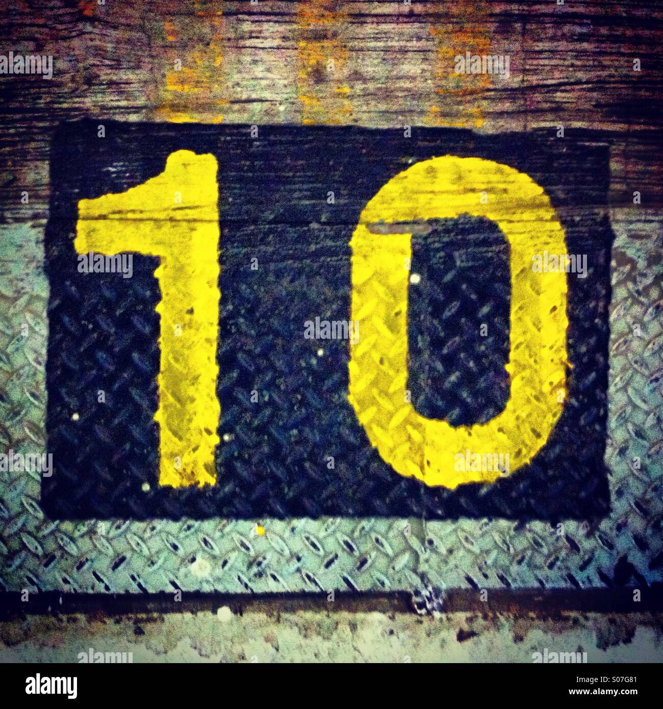 Nummer 10 in gelber Farbe auf unebenem Gelände Stockfoto