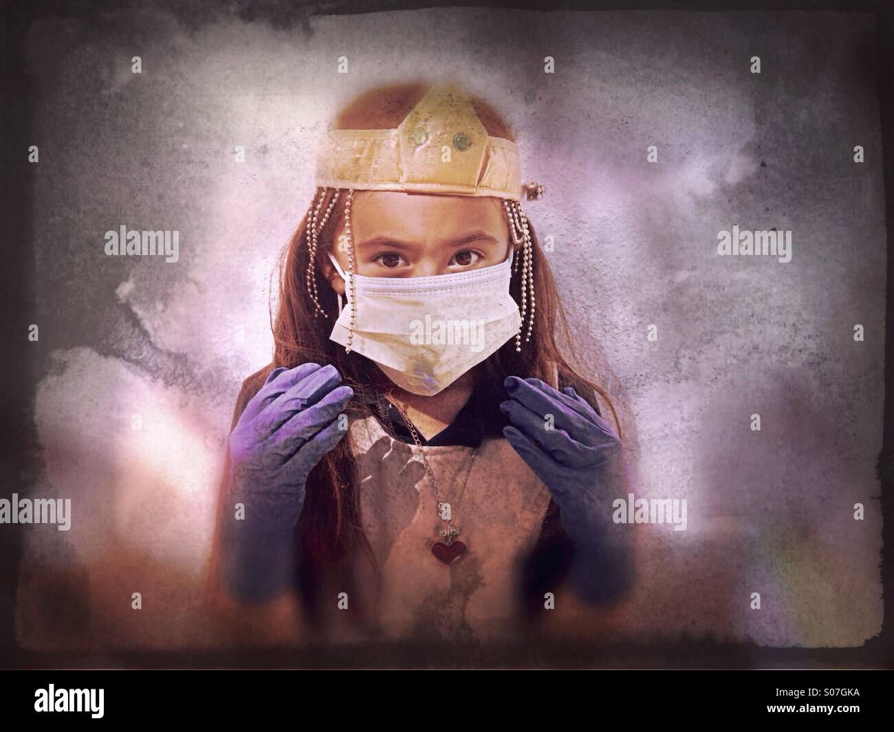 Ein sieben-Jahr-altes Mädchen spielen Dress-Up mit einem Mundschutz, Handschuhe und Krone mit dämonischen Augen. Stockfoto