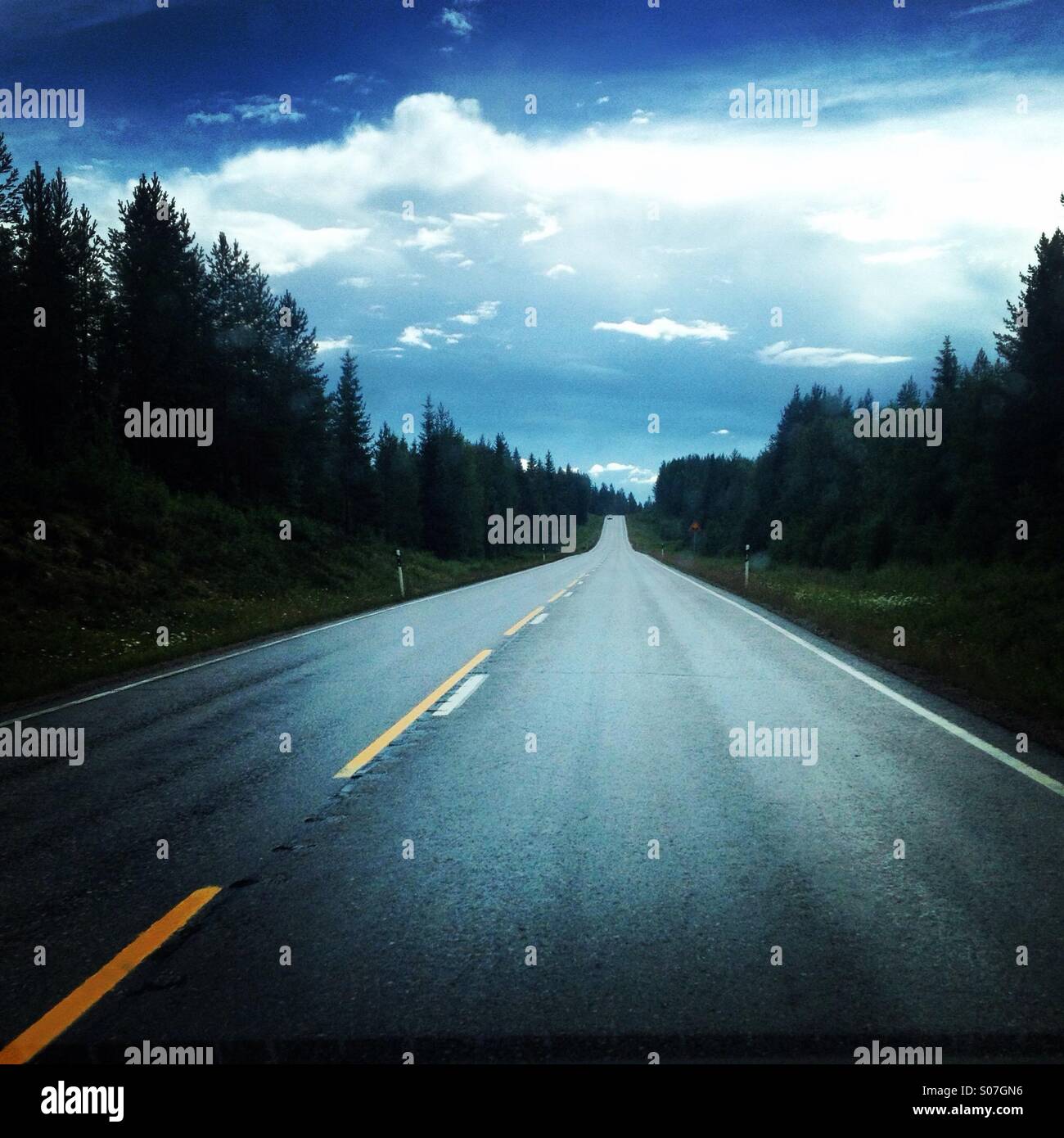 Eine lange gerade Straße im Norden Finnlands in der Nähe der Polarkreis Überschrift für einen typischen Sommer-Abend-Sturm Stockfoto