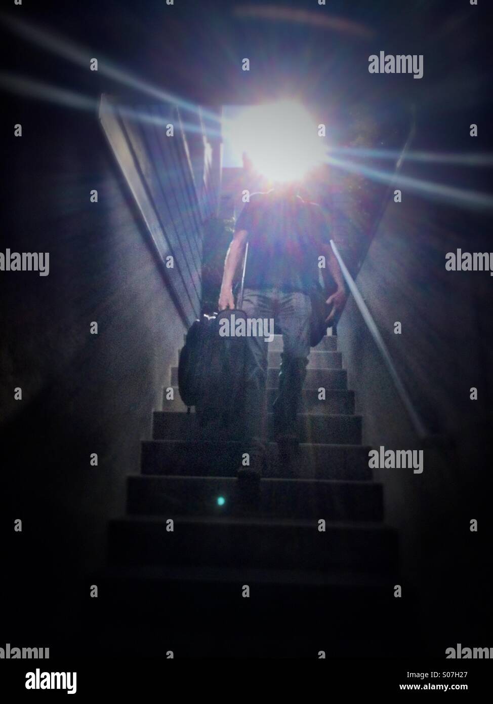 Mann mit Koffer die Treppen hinunter Stockfoto