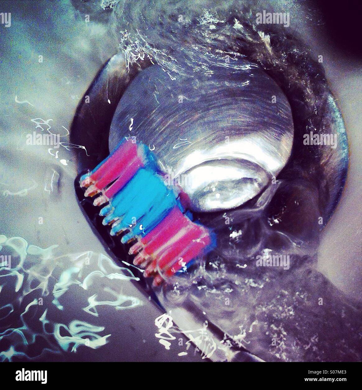 Reinigung die Zahnbürste mit Wasser in der Nähe der Doline Stockfoto