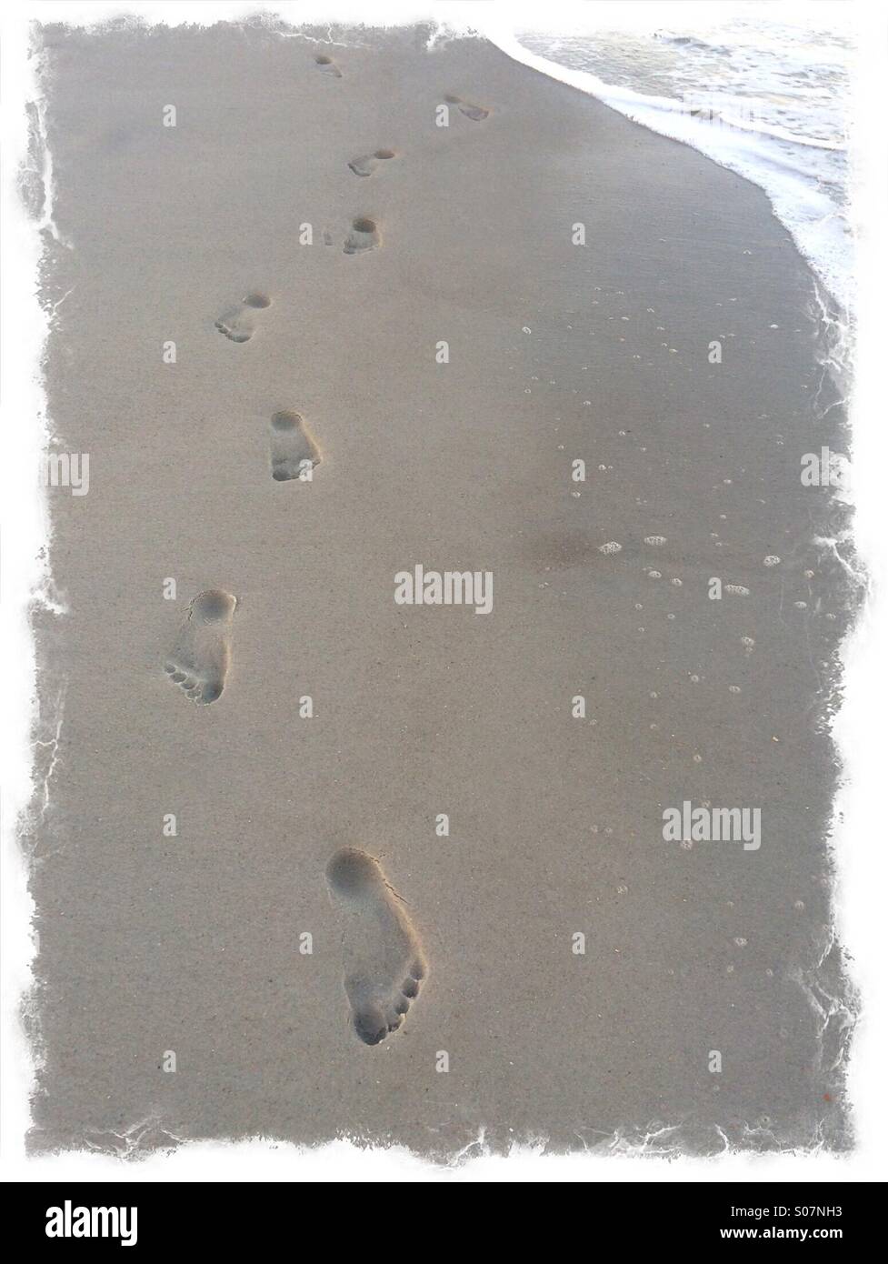 Einheitlicher Fußspuren im Sand, Jacksonville Beach, Florida, USA. Stockfoto