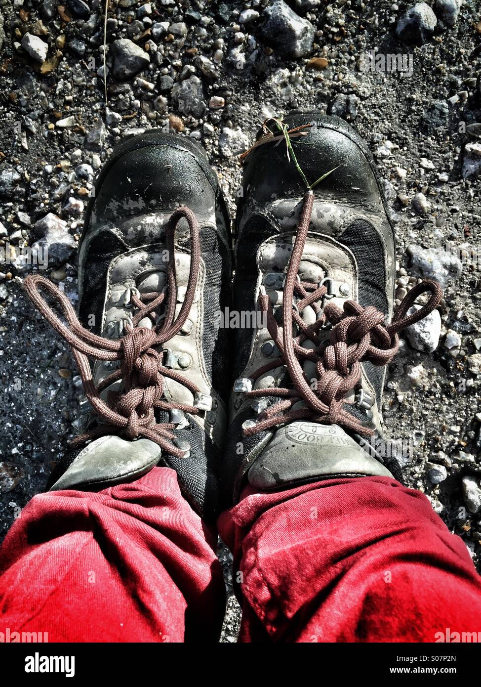 Zu Fuß Stiefel und rote Jeans 1st Person View auf unebenem Gelände Stockfoto