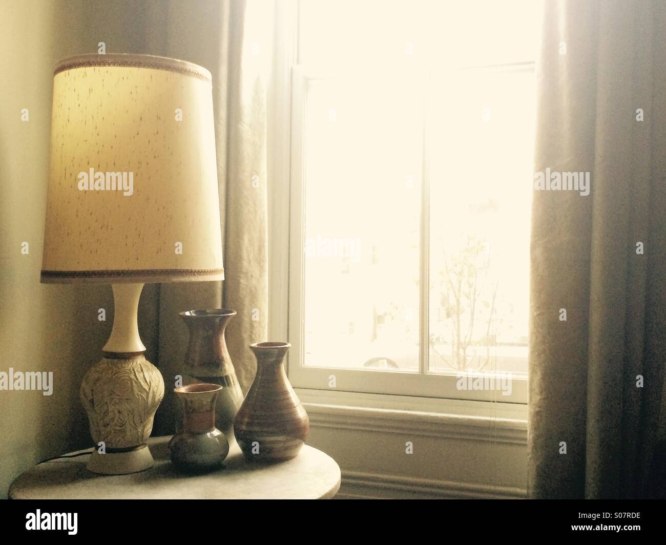 Lampen und Keramik-Kollektion in der Nähe von Fenster Stockfoto