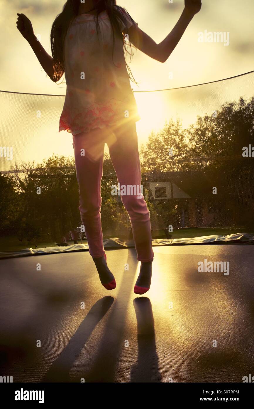 Bounce. Ein junges Mädchen, das Hüpfen auf einem Garten Trampolin - Spaß Stockfoto