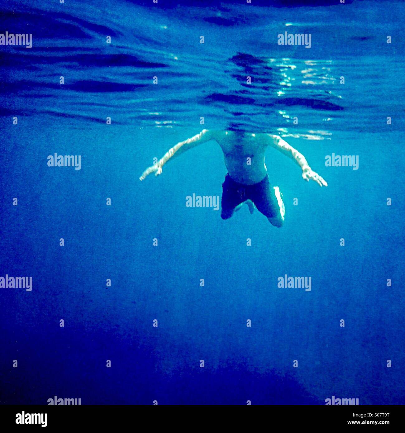Hai-Angriff! Ein Mann schwimmt von der Unterwasserwelt aus gesehen - gefährliches Ziel, seltsame, seltsame Art Stockfoto