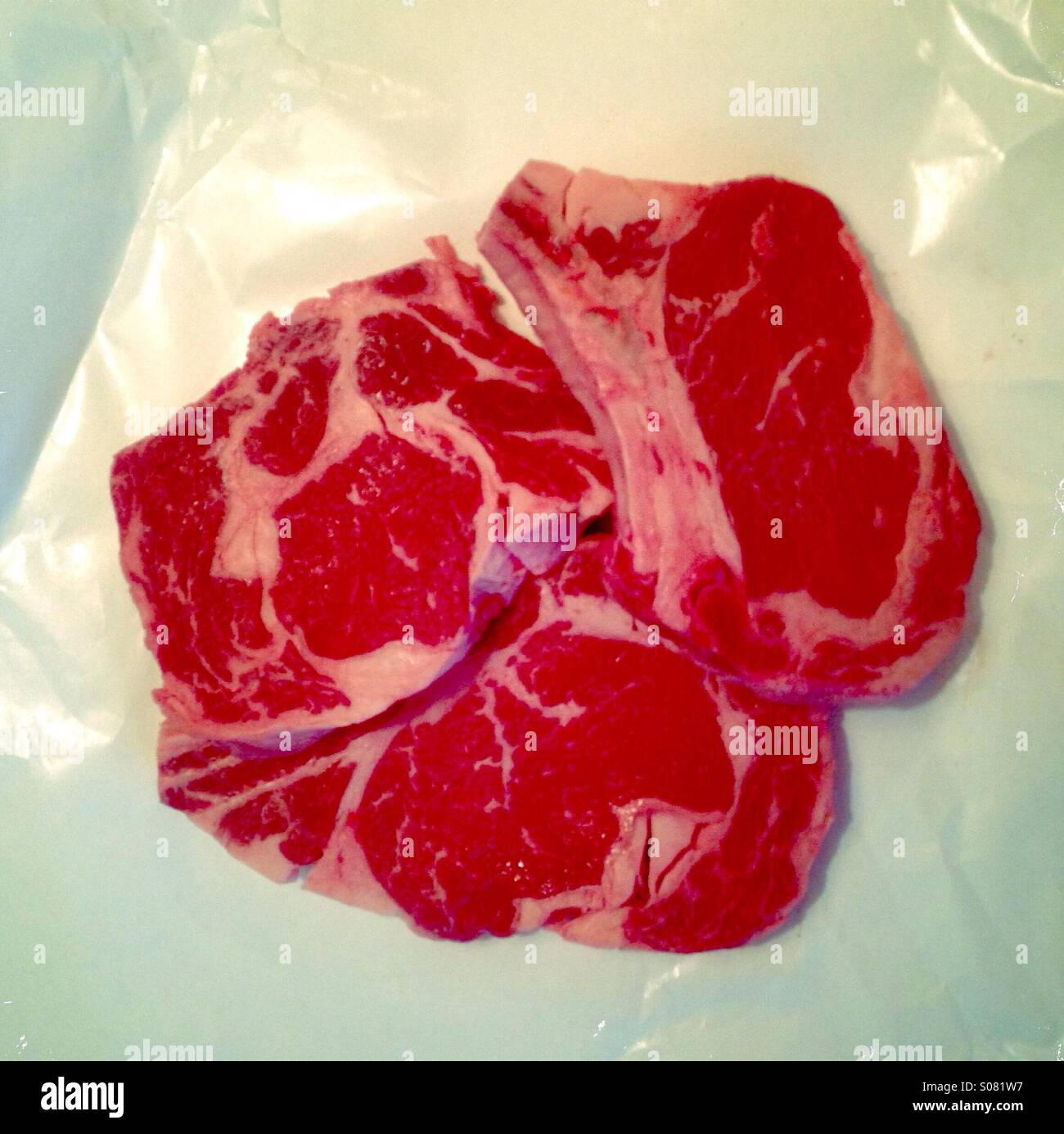 Ribeye Steaks auf weißem Papier Metzger - Smartphone-aufgenommenes Stockfoto