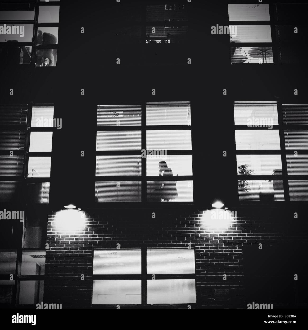 Überstunden-Büro blockieren in der Nacht mit silhouette - Smartphone-aufgenommenes Stockfoto