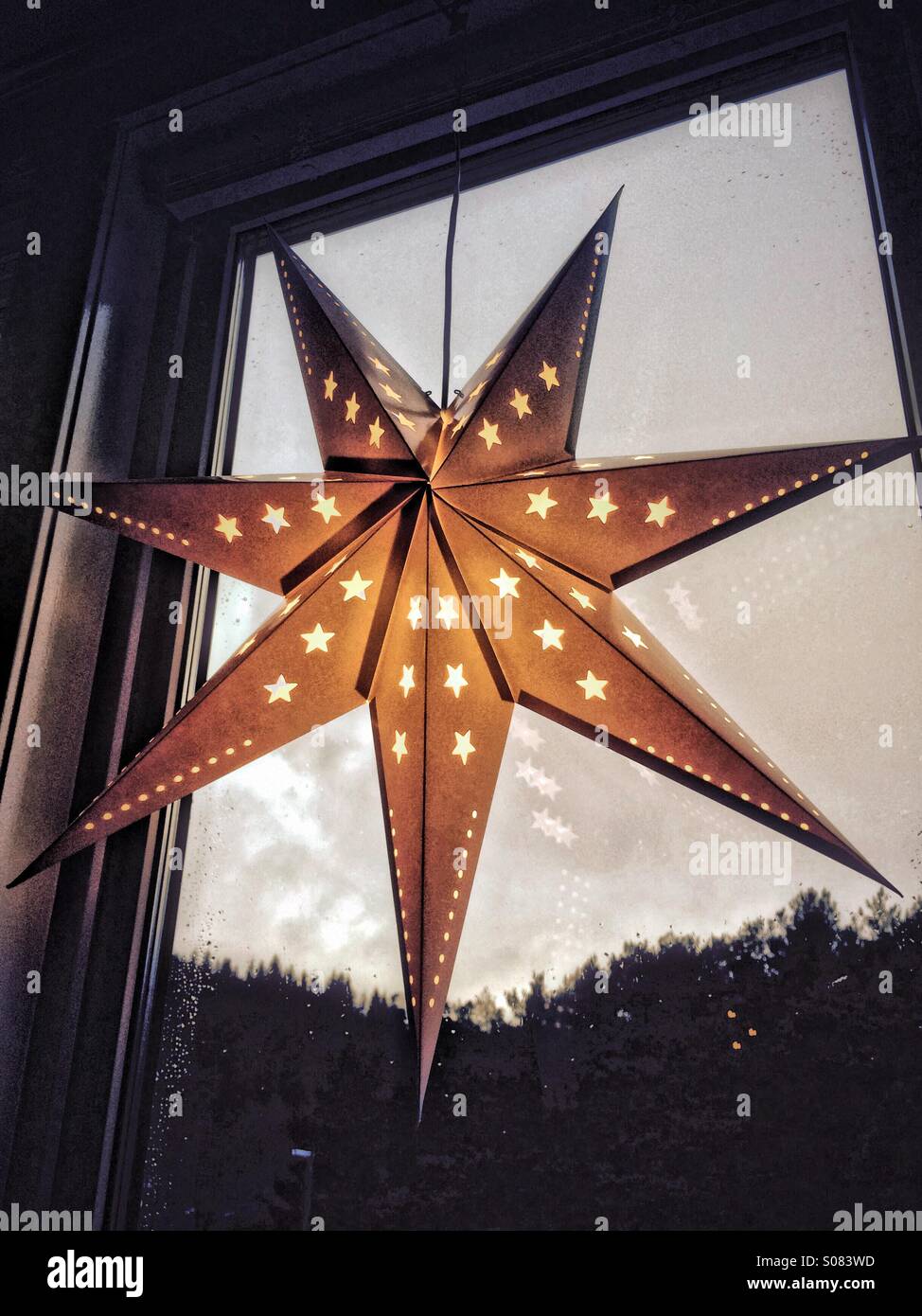 Beleuchtete Nacht Sterne als Weihnachtsdekoration in einem Fenster hängen. Stockfoto