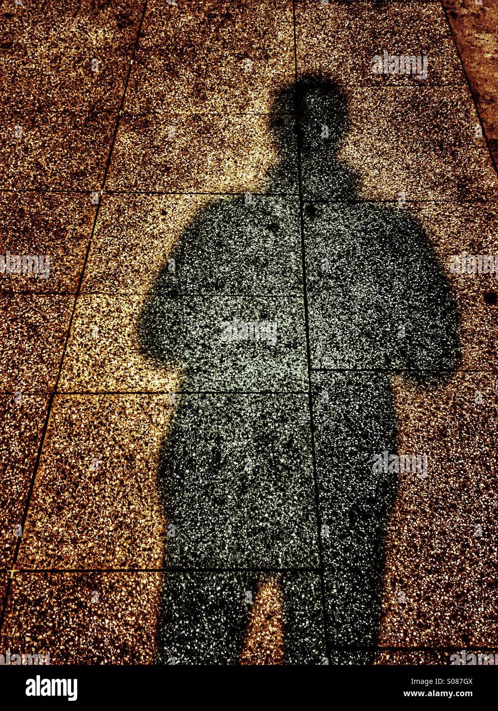 Schatten eines Mannes auf dem Bürgersteig Stockfoto