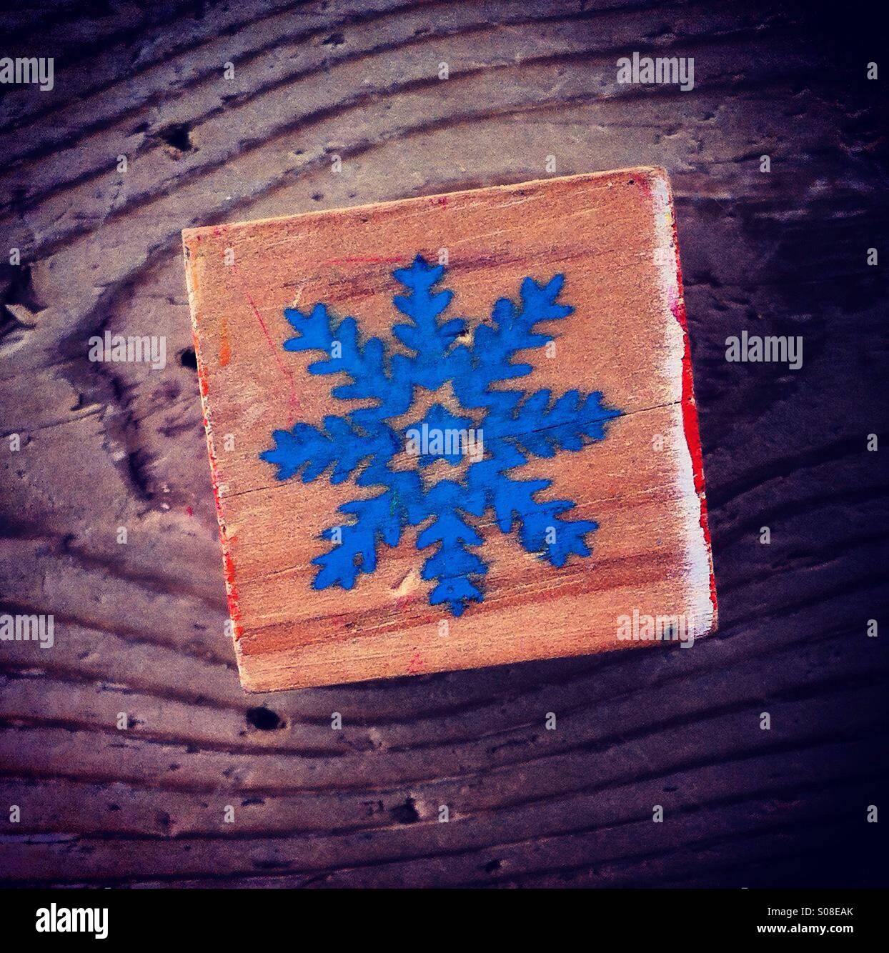 Blaue Schneeflocke auf eine Holzplatte gemalt Stockfoto