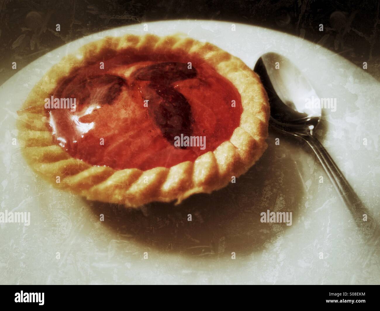 Eine Erdbeere Torte auf einem weißen Teller mit einem Teelöffel Stockfoto