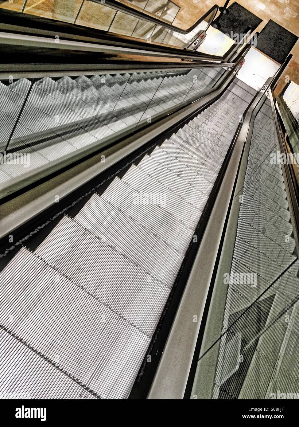 Die Rolltreppe in einem leeren Gebäude hinunter. Stockfoto