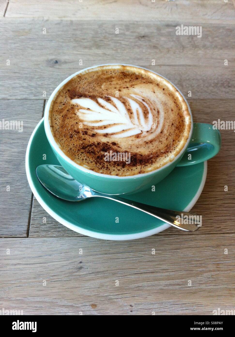 Eine Tasse Latte mit Kunst oben drauf - Smartphone-aufgenommenes Stockfoto