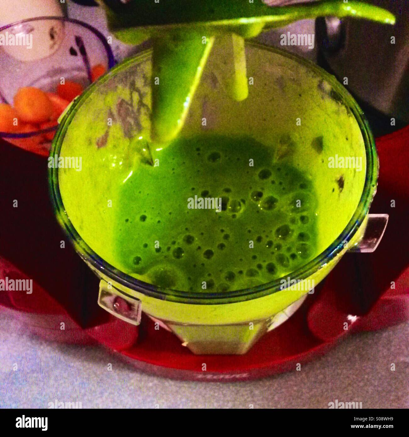 Frischer grüner Gemüsesmoothie in einem Mixer - Smartphone-aufgenommenes Stockfoto