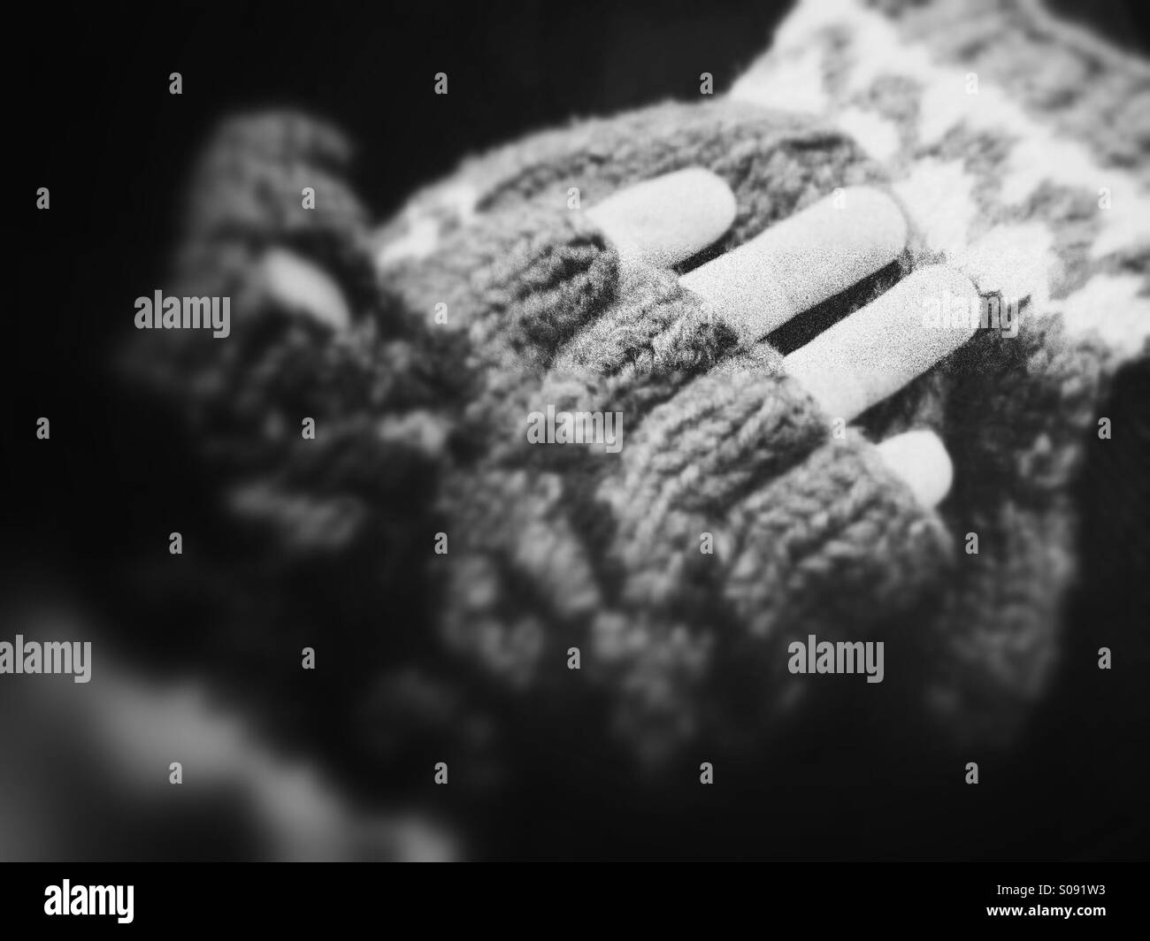 B&W verschwommenes Foto von fingerlose Handschuhe mit Fäustling deckt in schwarz / weiß Stockfoto