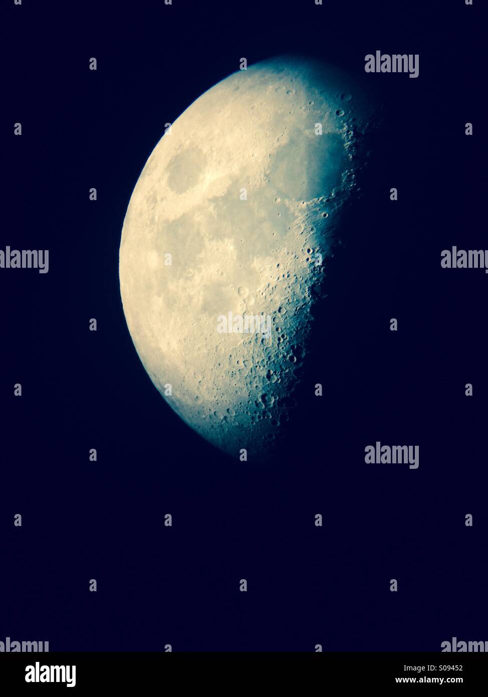 Afokale Teleskop-Blick auf das erste Quartal Mond im Dezember - Smartphone-aufgenommenes Stockfoto