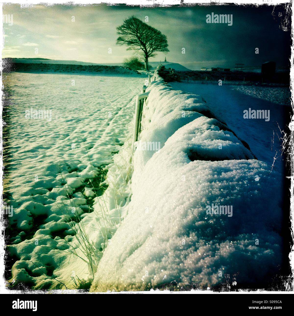 Verschneite Wand- und Felder mit Stoodley Hecht im Hintergrund, in der Nähe von Hebden Bridge, West Yorkshire. VEREINIGTES KÖNIGREICH. - Smartphone-aufgenommenes Stockfoto