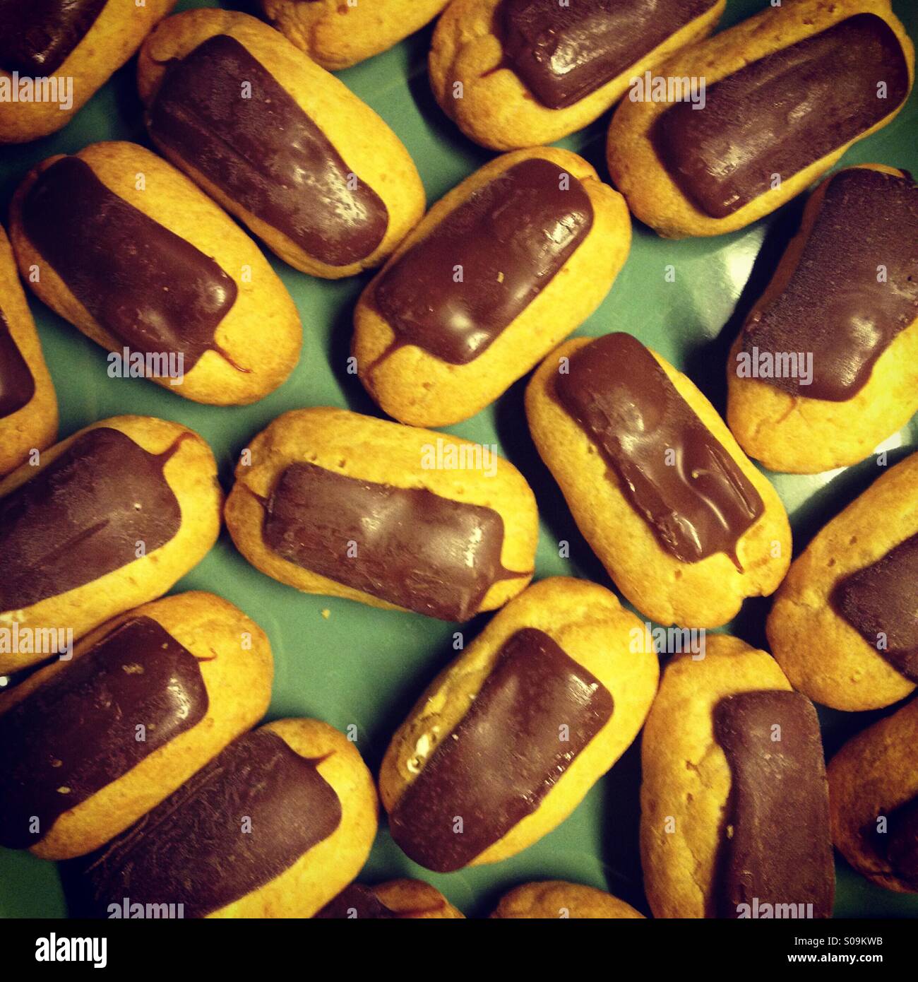 Einen Teller mit Gebäck Mini Schokolade Eclair. Full-Frame-Hintergrund Stockfoto