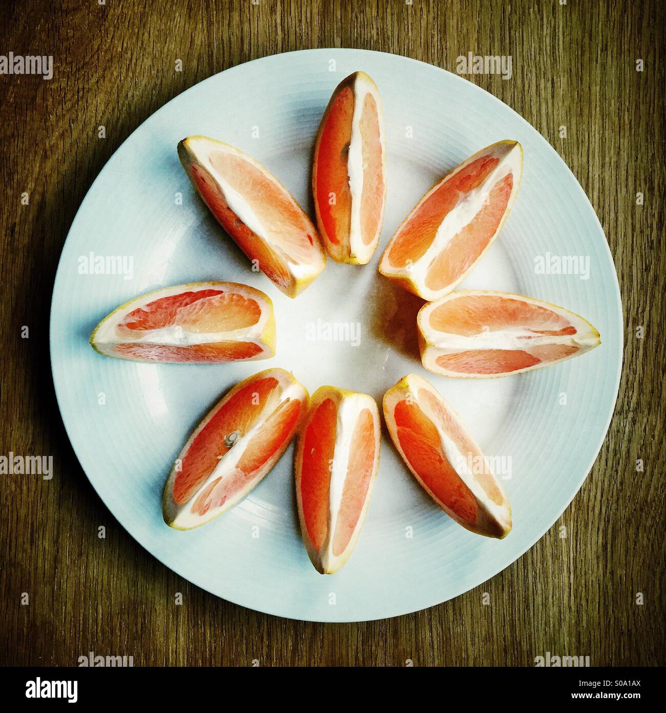 Ein rosa Grapefruit in Segmente geschnitten - Smartphone-aufgenommenes Stockfoto