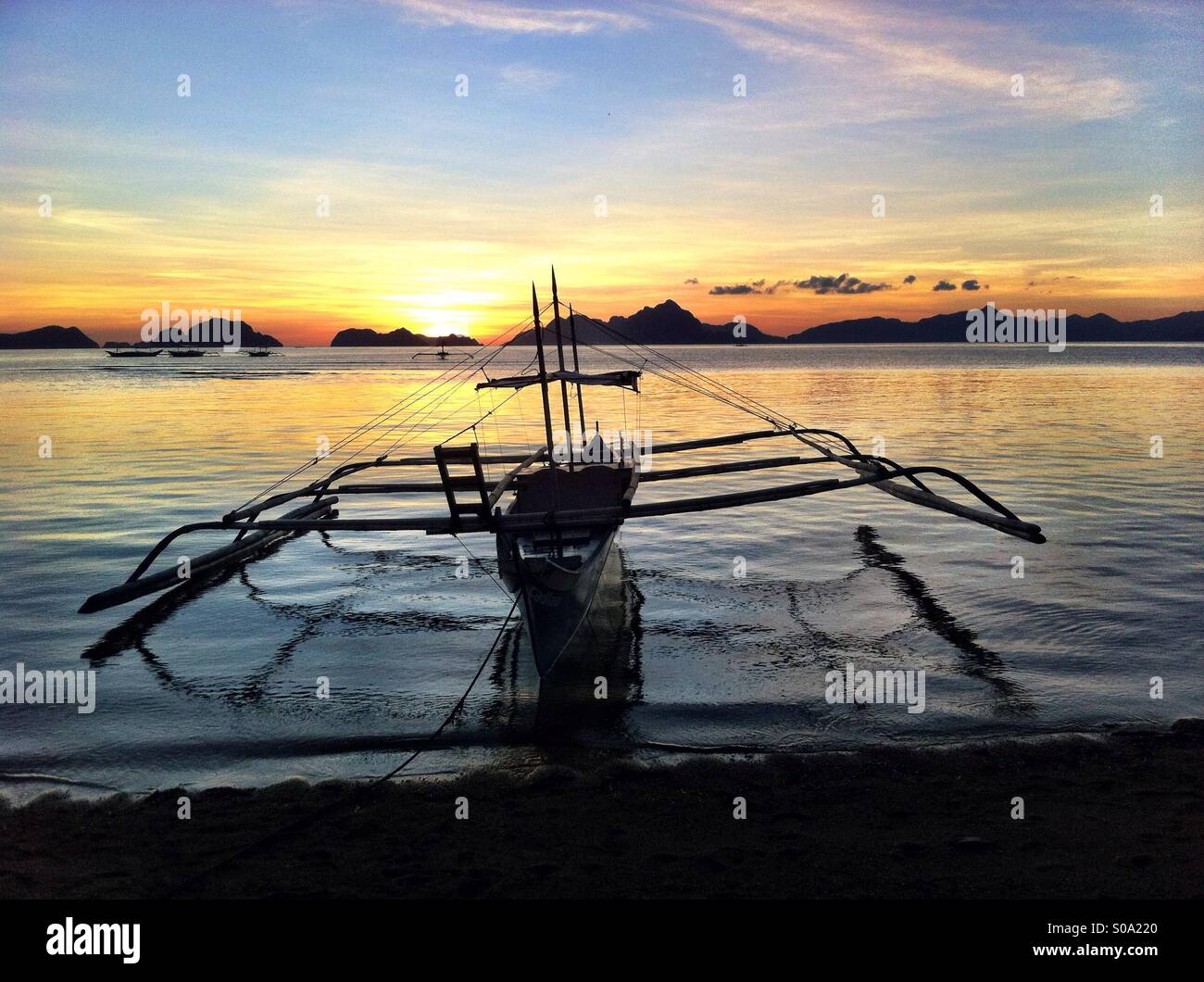 Silhouette der traditionellen philippinischen Bangka Fischerboot in El Nido auf der Insel Palawan mit tausend Inseln bei Sonnenuntergang Stockfoto