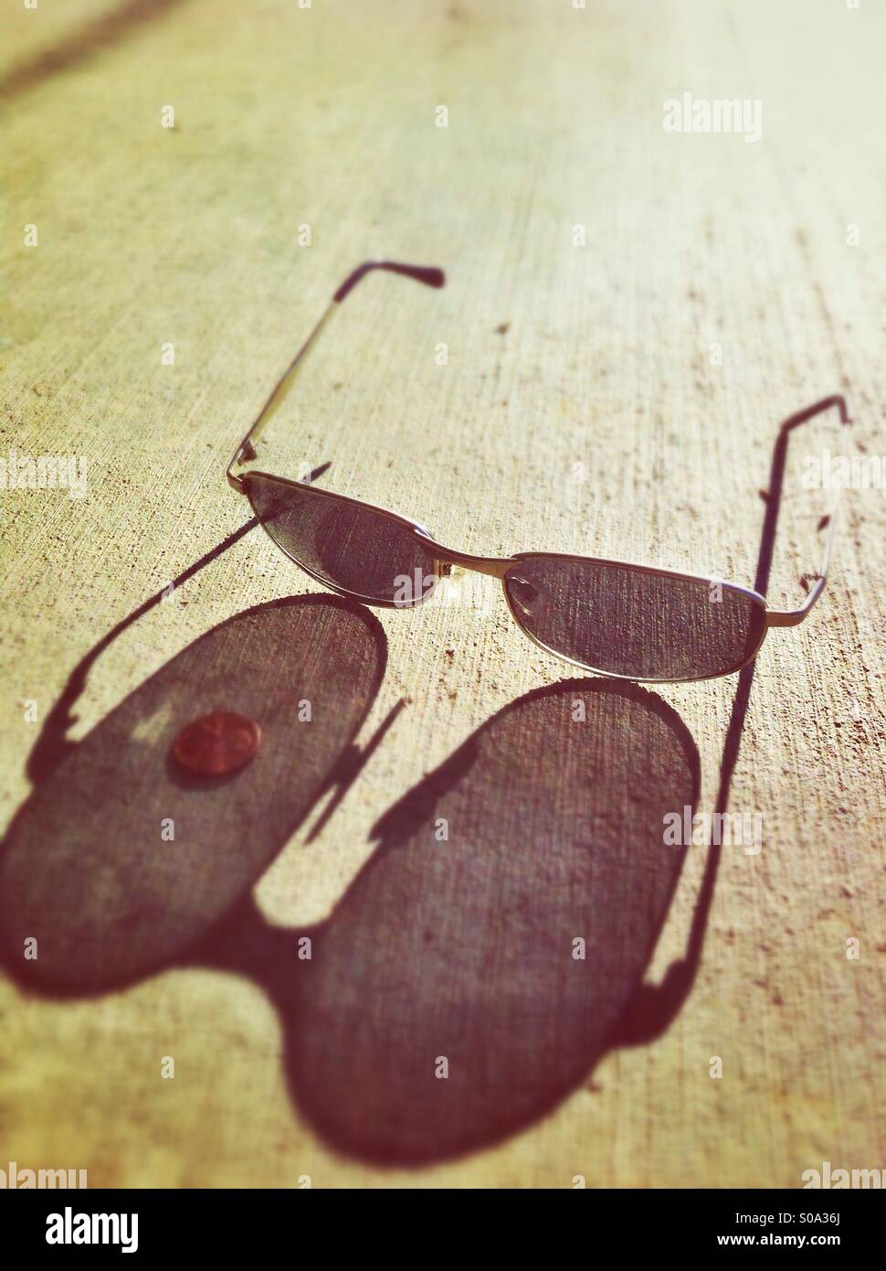 Sonnenbrille auf den Bürgersteig lange Schatten Stockfoto