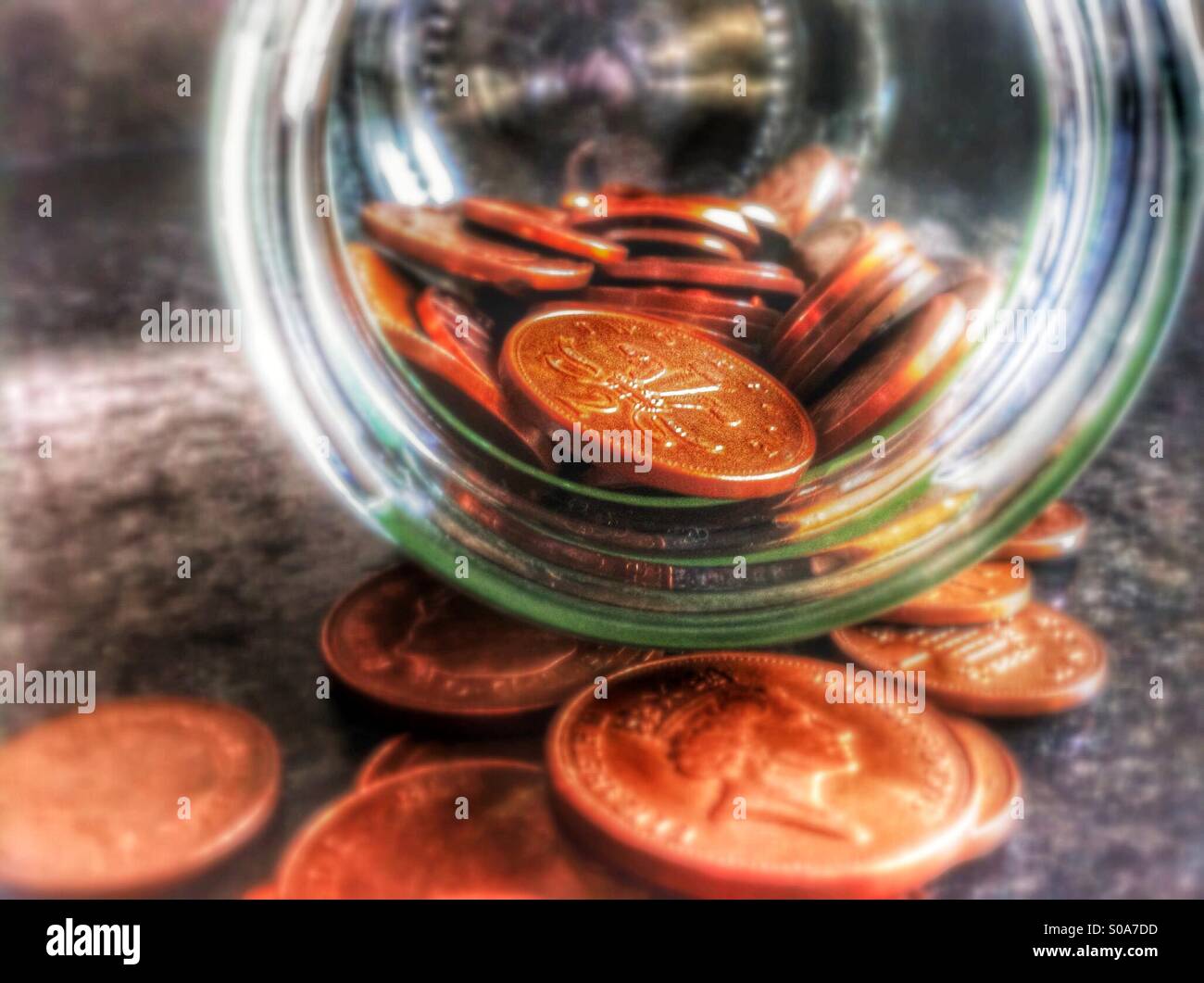 Nahaufnahme von Münzen aus dem Glas verschütten - Smartphone-aufgenommenes Stockfoto