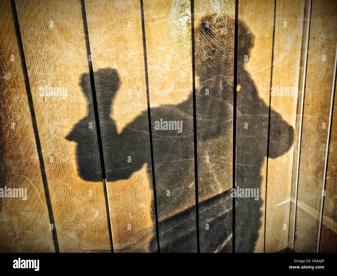Ein Mann wirft einen Schatten auf die Wand auf seiner Hand zählen. Die Zahl Null. Stockfoto