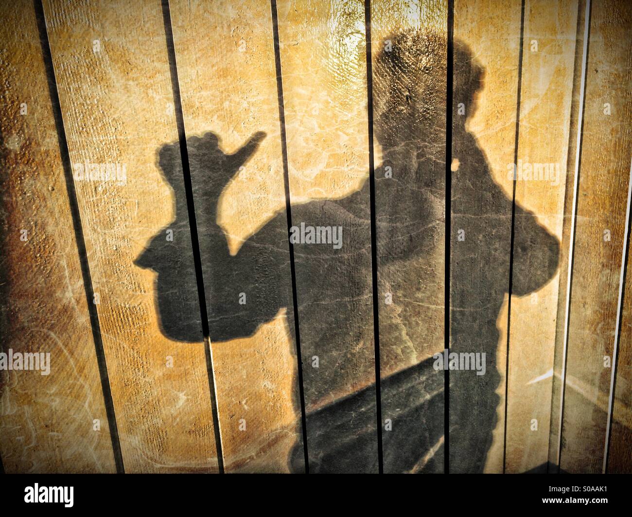 Ein Mann wirft einen Schatten auf die Wand auf seiner Hand zählen. Nummer eins. Stockfoto