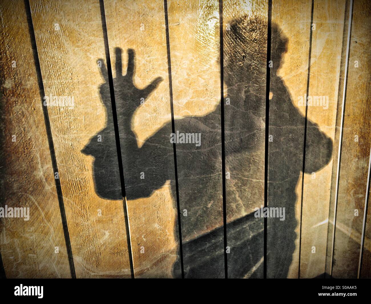 Ein Mann wirft einen Schatten auf die Wand auf seiner Hand zählen. Nummer vier. Stockfoto