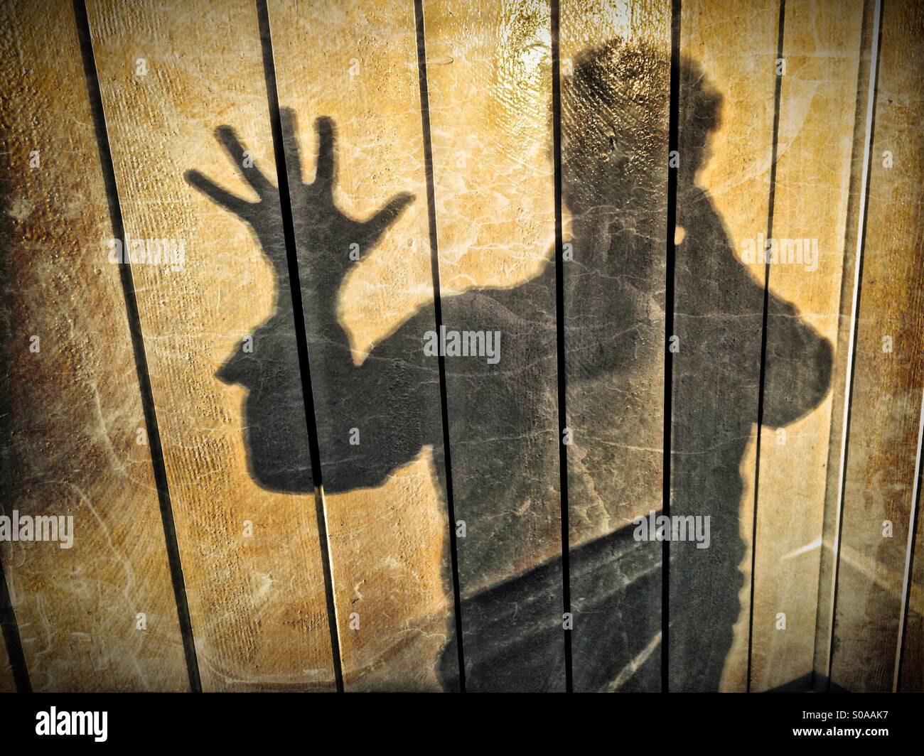 Ein Mann wirft einen Schatten auf die Wand auf seiner Hand zählen. Nummer fünf. Stockfoto