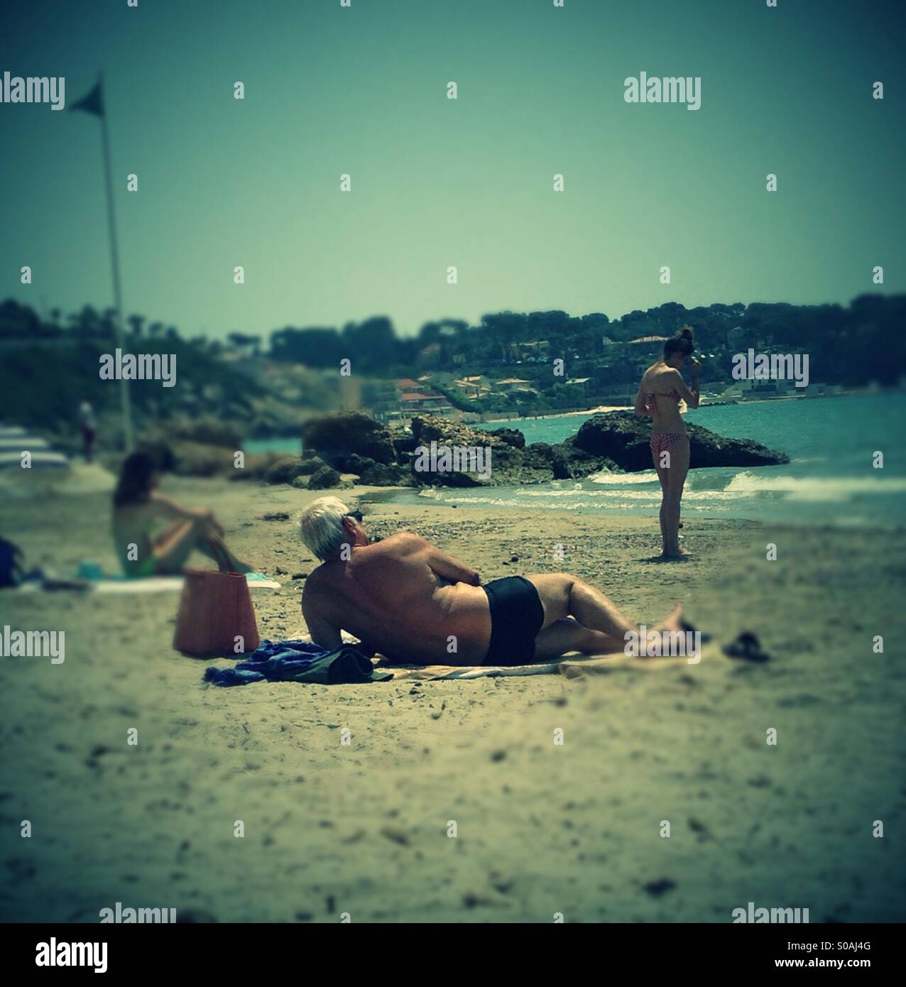 Älterer Mann Sonnenbaden - Smartphone-aufgenommenes Stockfoto