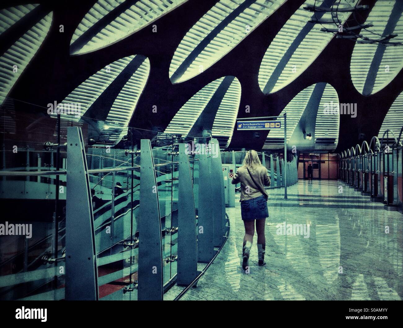 Junge Frau, die zu Fuß in der Ankunftshalle am Moskauer Flughafen "Scheremetjewo" Stockfoto